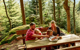 Eine Familie von Wanderern macht eine Pause im Wald bei Bodenmais