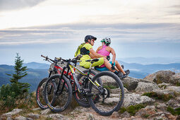 Zwei Mountainbiker machen eine Pause und haben eine tolle Aussicht auf den Bayerwald rund um Bodenmais.